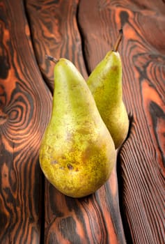 Two pears on an old brown wooden background