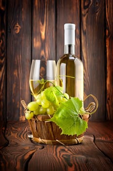 White wine with grapes on wooden background