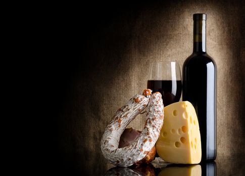Wine bottle and cheesei on a background of old canvas
