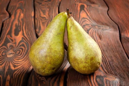 Two pears on an old brown wooden background