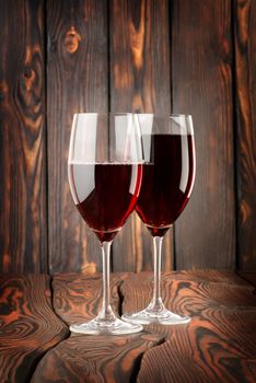Two glass of red wine on a wooden background
