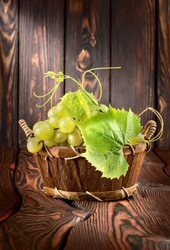 Grapes in a basket on a wooden background
