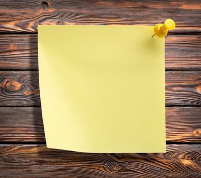 Yellow notebook on a wooden brown wall