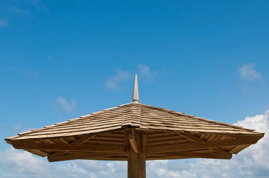 wooden parasol against a blue sky background (copy-space available)
