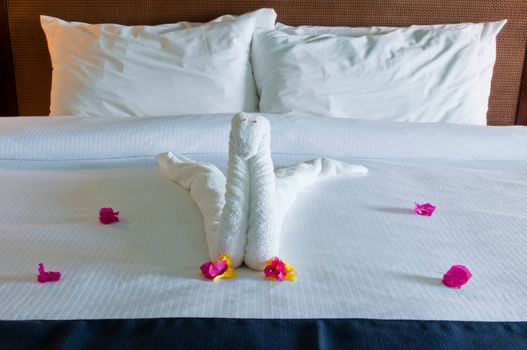 beautiful swan made from towels and bougainvillea flowers in the hotel bedroom (typical in The Caribbean resorts)