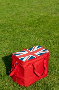 red lunch bag with the union flag (United Kingdom) on the grass field (copy-space available)