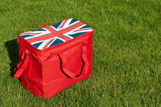 red lunch bag with the union flag (United Kingdom) on the grass field (copy-space available)