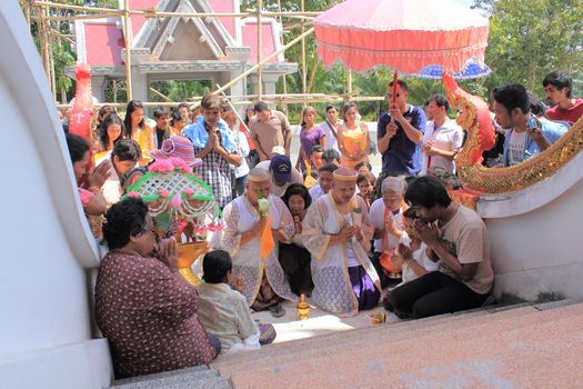 NAKON SI THAMMARAT, THAILAND - NOVEMBER 17 : Unidentified Thai people pour water after circle temple with offering Buddhist ordination ceremony on November 17, 2012 in Nakon Si Thammarat, Thailand.