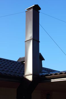Chimney and roof on the sky background.