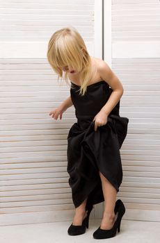 Girl 3 years old in my mother's black dress and high heels