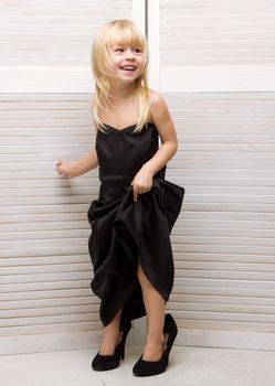 Girl 3 years old in my mother's black dress and high heels