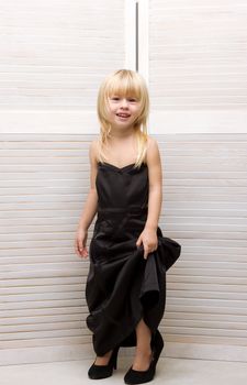 Girl 3 years old in my mother's black dress and high heels