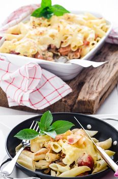 fresh baked Rigatoni casserole with cheese sausage, bacon, tomatoes, cream and herbs