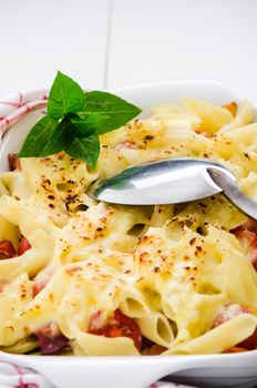 fresh baked Rigatoni casserole with cheese sausage, bacon, tomatoes, cream and herbs