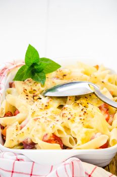 fresh baked Rigatoni casserole with cheese sausage, bacon, tomatoes, cream and herbs