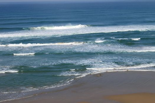 a sandy beach beside the sea under a blue sky