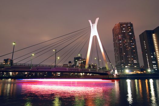 Chuo-Ohashi suspension bridge in Tokyo, Japan with light traces of moving ship