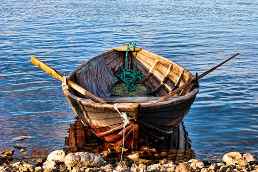 An old rowing boat lies on a beach