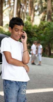 A young boy talking on a cell phone.