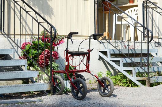 A walking frame stands between two staircases