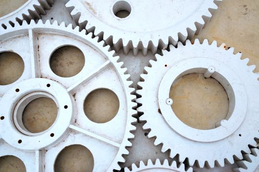 set of big industrial metallic gears on the concrete floor background