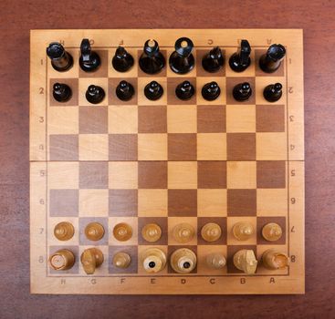 chess board on top of the background of a wooden table..