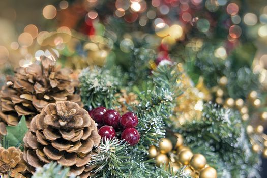 Christmas Decoration Garland with Berries Pine Cones and Coloful Blurred Bokeh Lights Background