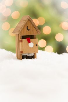 Santa in A Miniature Outhouse on Snow Over and Abstract Background.