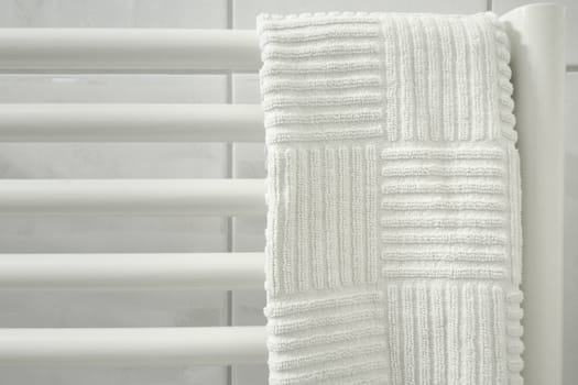 light soft image of white bath towel hanged up on the  radiator