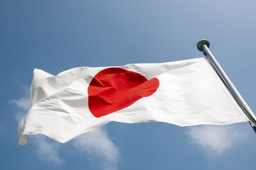 state Japanese flag on the strong wind over blue sky background