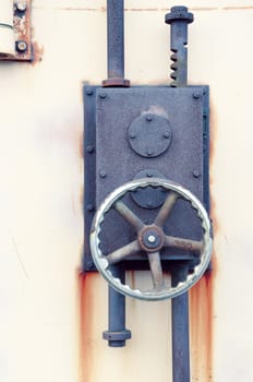 rusty iron lock on the harbour warehouse door; focus on the wheel and lock's body