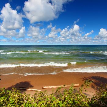 Beach landscape of waves crashing along the shores of Lake Superior in Michigan.