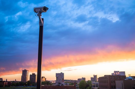 Urban security video camera outdoors at sunset