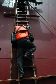 a man climbing a ladder on a tanker