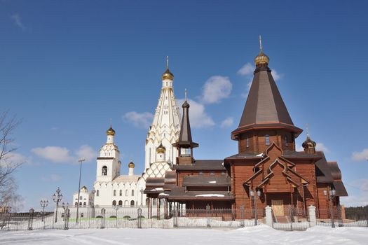 wooden and stone Orthodox Church buildings under clear blue sky; All Saints orthodox Church in Minsk, Belarus