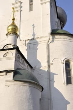 evening shadow of orthodox cross on white wall at Novodevichy convent site in Moscow