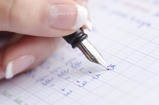 hand of girl writing mathematics at school
