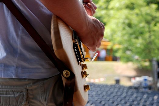 Musician plays his electric guitar during a soundcheck on stage