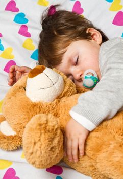 Sweet child sleeping with teddy bear 