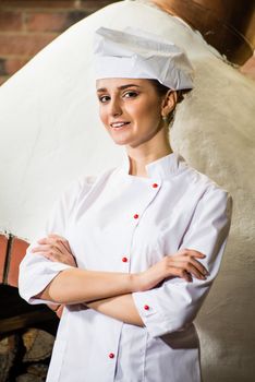 portrait of a cook, is on the traditional kitchen, crossed her arms