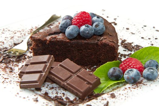 Piece of chocolate cake with fresh berry on white background 