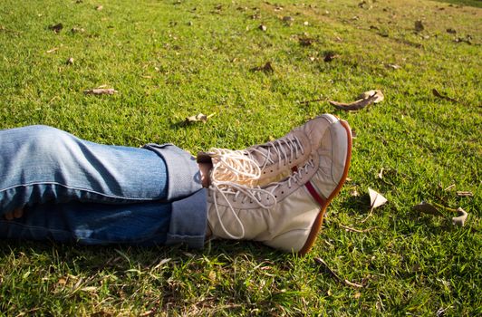 A cute pair of boxing-style shoes relaxed over a grassy hill top