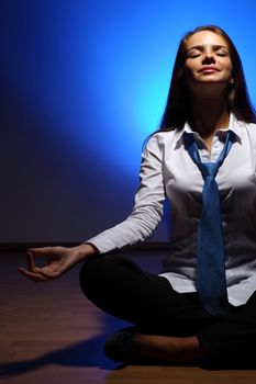 Young business woman sitting in asana lotus and meditating