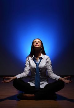 Young business woman sitting in asana lotus and meditating