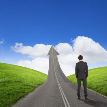 Concept of the road to success with a businessman standing on the road