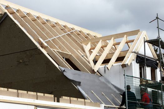 Construction of a new roof in progress. Wood supports are covered in roofing felt in preparation for tiling