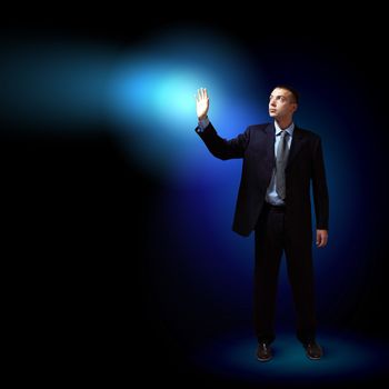 Young successful businessman holding a shining light in his hand as a symbol of success and advancement.