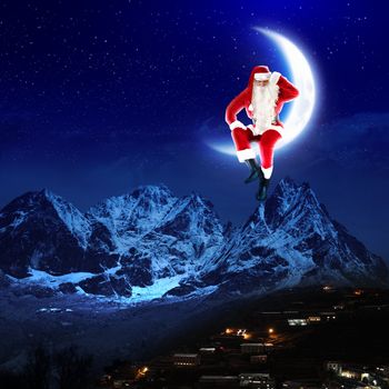 photo of santa claus sitting on the moon with a city and mountains below