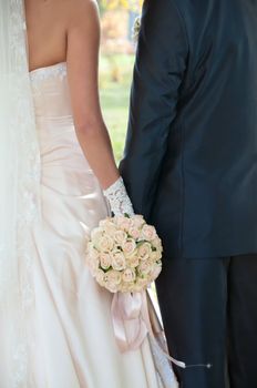 white wedding bouquet in the hands of the bride and groom 