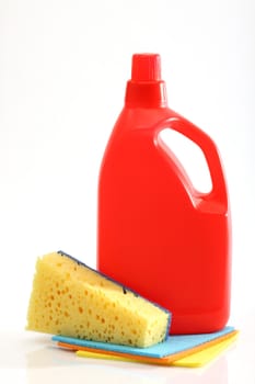 Plastic detergent bottle and sponge over white